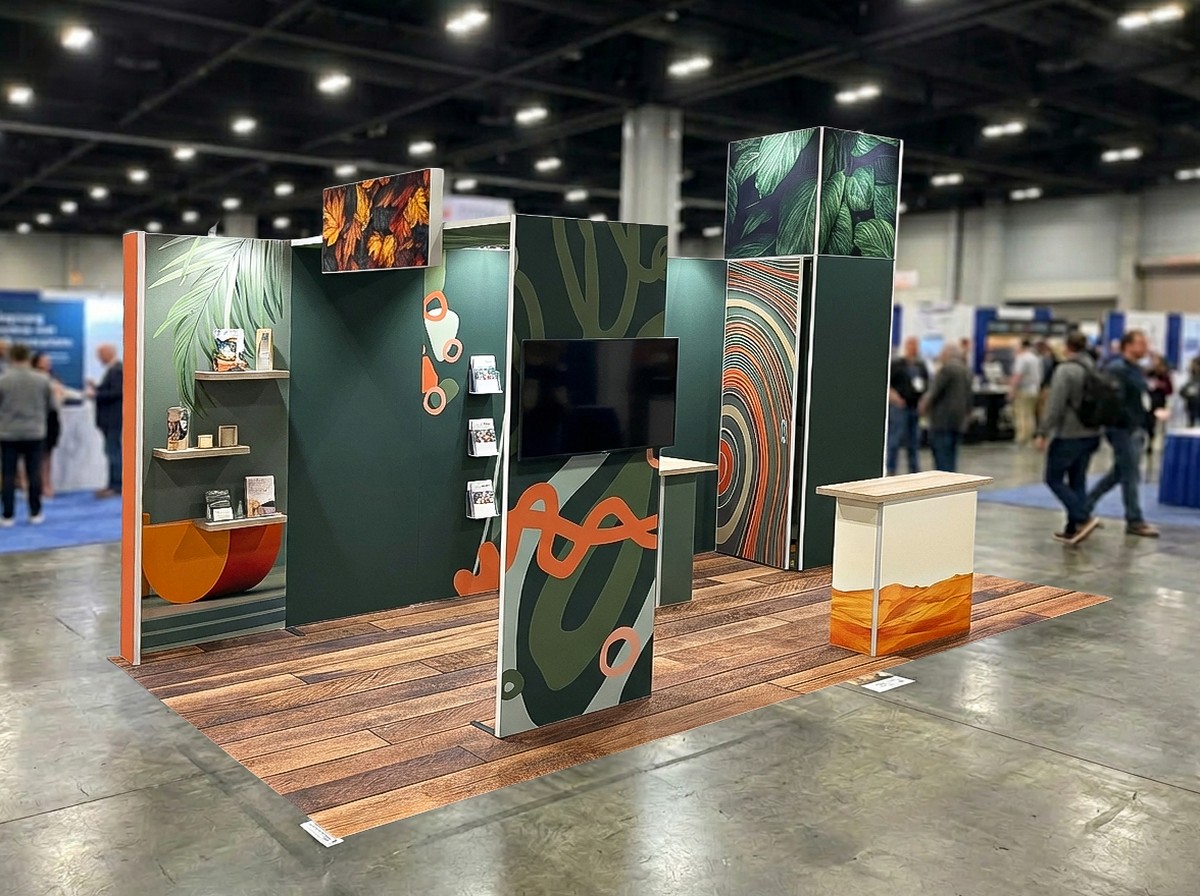 Kompakter modularer Messestand mit grünen und orangefarbenen Grafikflächen