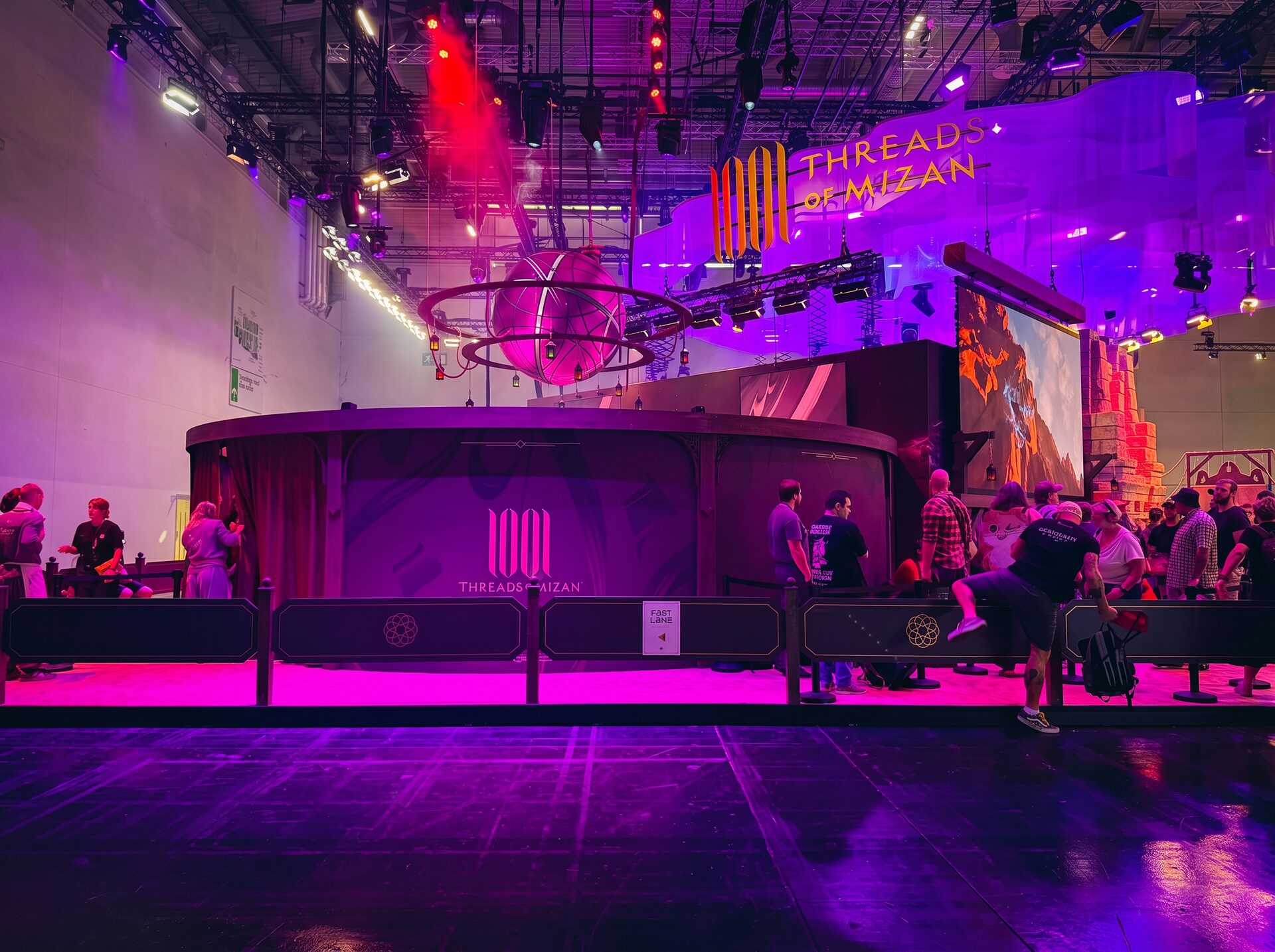 Messeauftritt Threads of Mizan auf der gamescom in violettem Licht